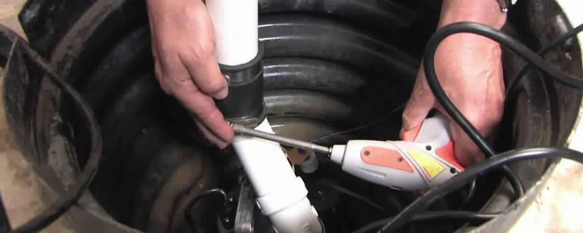 Sump pump installation technician connecting PVC discharge piping in Charleston, SC
